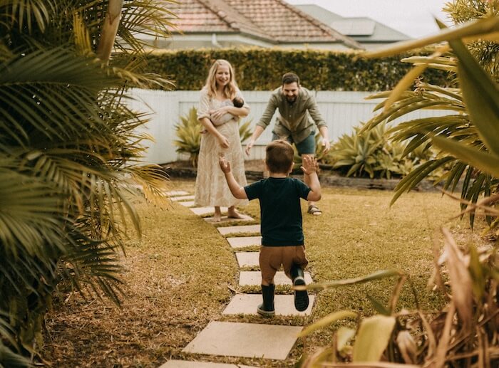 doing things differently Maggie Stara walking with her family and dog along a garden path
